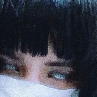 a woman with black hair and a mask covering her face